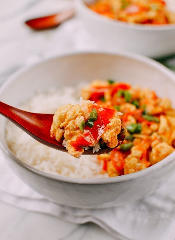 A spoonful of egg and tomato stir-fry, served with rice.